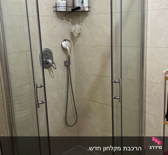 מקלחון זכוכית עם מדף בקבוקים ומזלף יד